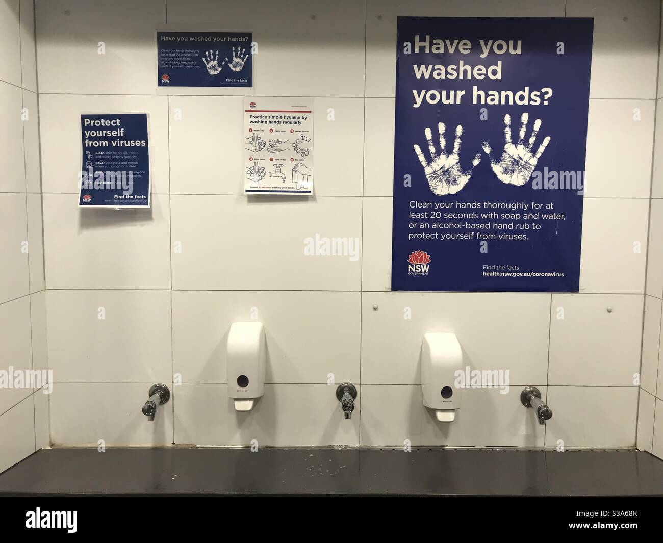 COVID-19 (coronavirus) hand washing signs above the wash basin in the men’s toilets at Bondi Junction train station. Stock Photo