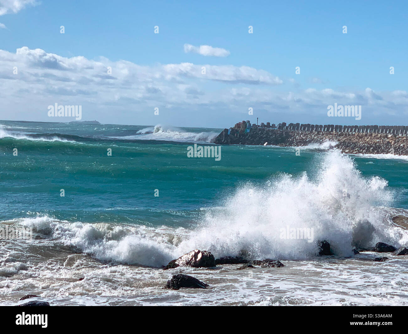 Sea water leaping up as waves crashing onto rocks on the shore, Australia - Smartphone Captured Stock Image