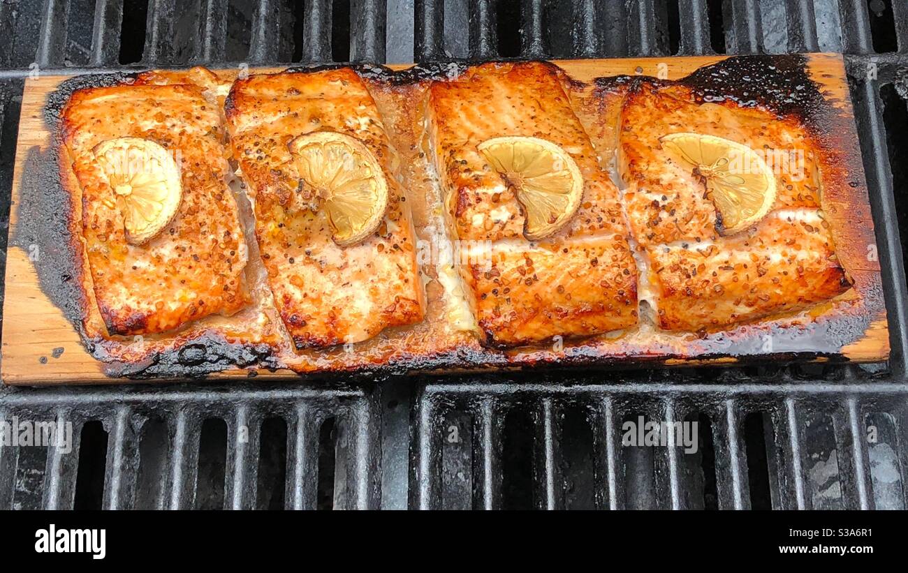 Salmon grilled on cedar boards on barbecue with spices and lemon, 2020 - Smartphone Captured Stock Image
