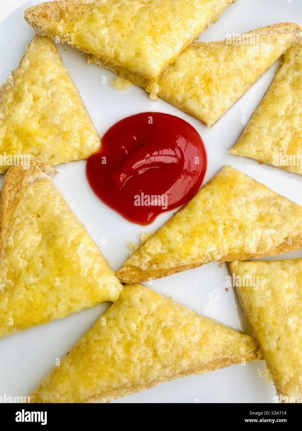 Cheese on toast with a dollop of tomato sauce Stock Photo