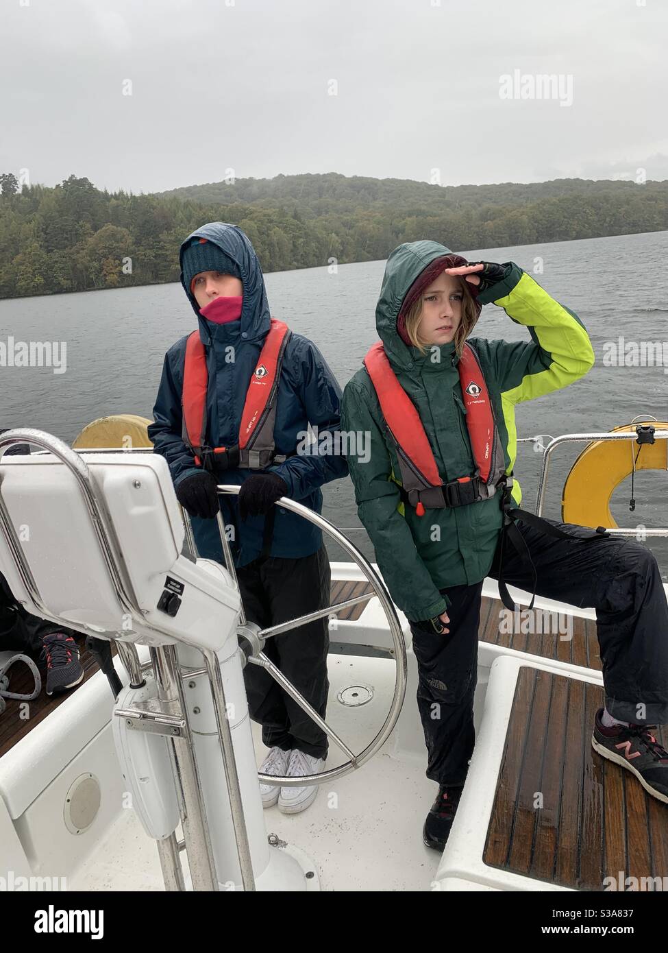 Children sailing a yacht on Lake Windermere, Lake District UK Stock Photo