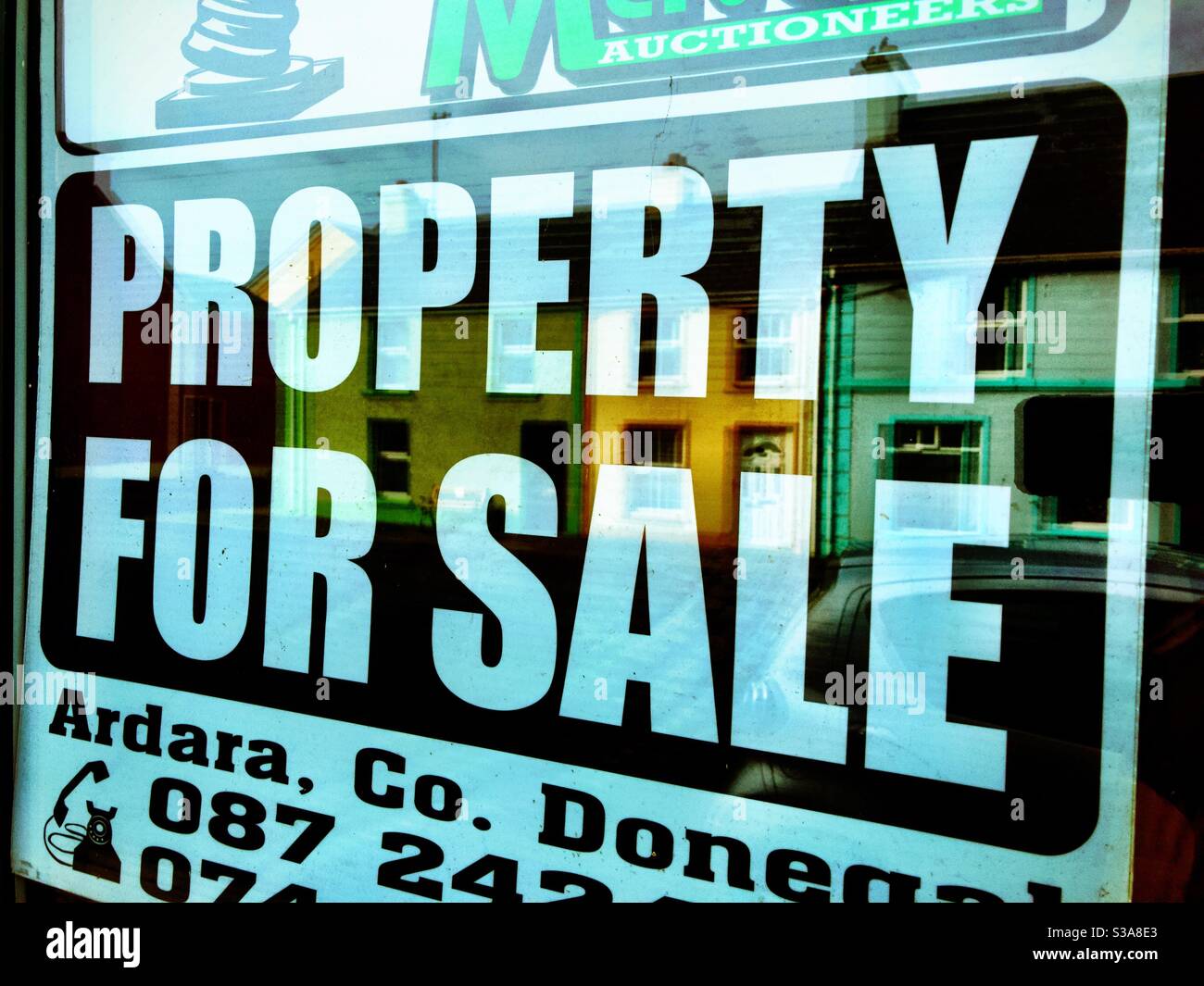 Property for sale in rural Ireland reflection of sign in window - Smartphone Captured Stock Image