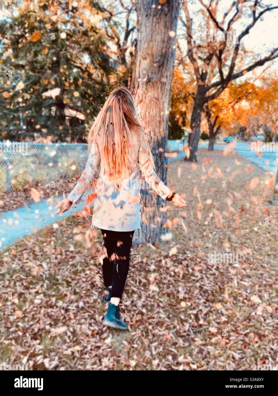Girl throwing leaves in fall season Stock Photo Alamy