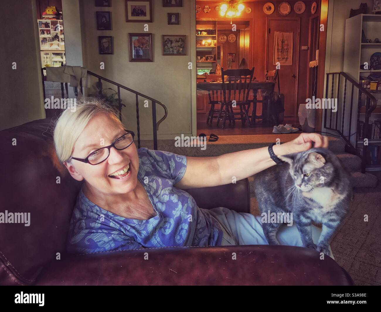 Happy lady pets her kitty cat - Smartphone Captured Stock Image