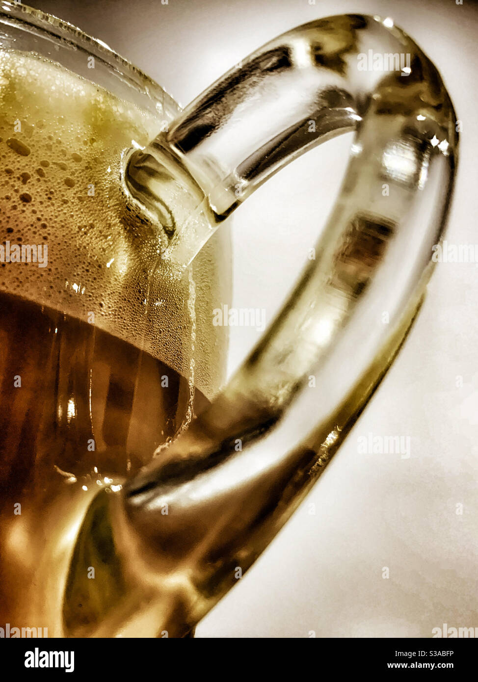 Closeup of a Glass coffee cup in the light, focussing on the handle Stock Photo