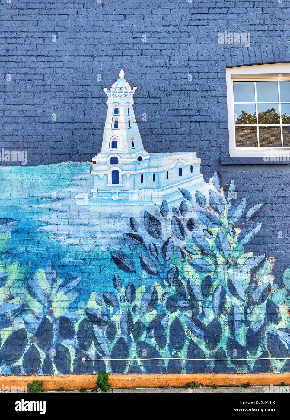 A lighthouse mural painted on the side  of a building wall. - Smartphone Captured Stock Image