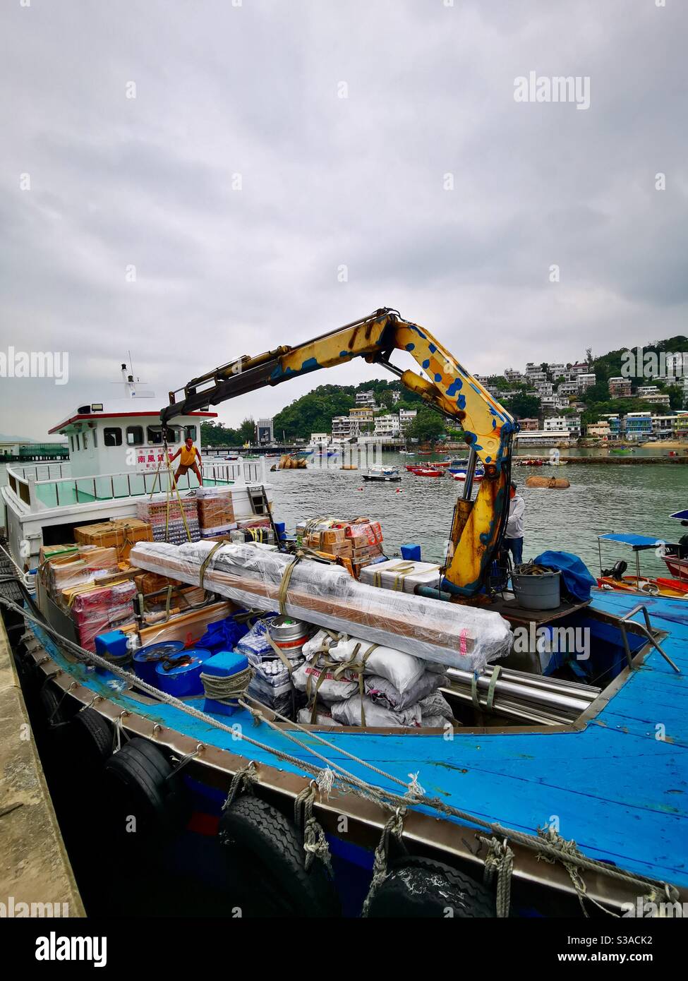 the Gaido ship unloading merchandise at the Yung shue wan pier in lamma island. - Smartphone Captured Stock Image