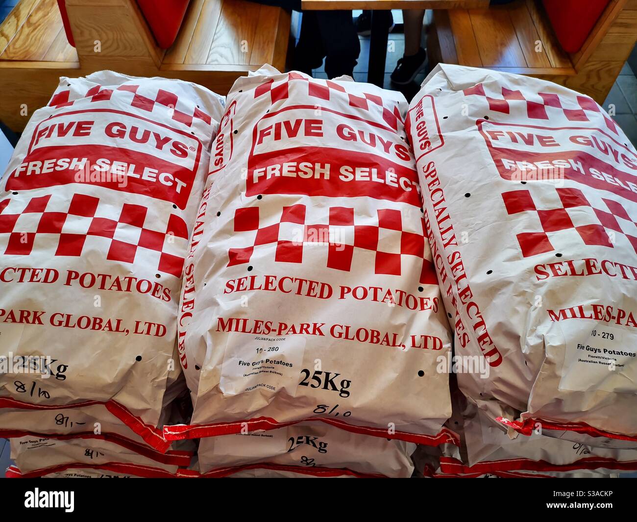 Five Guys 25 kg potato bags. - Smartphone Captured Stock Image