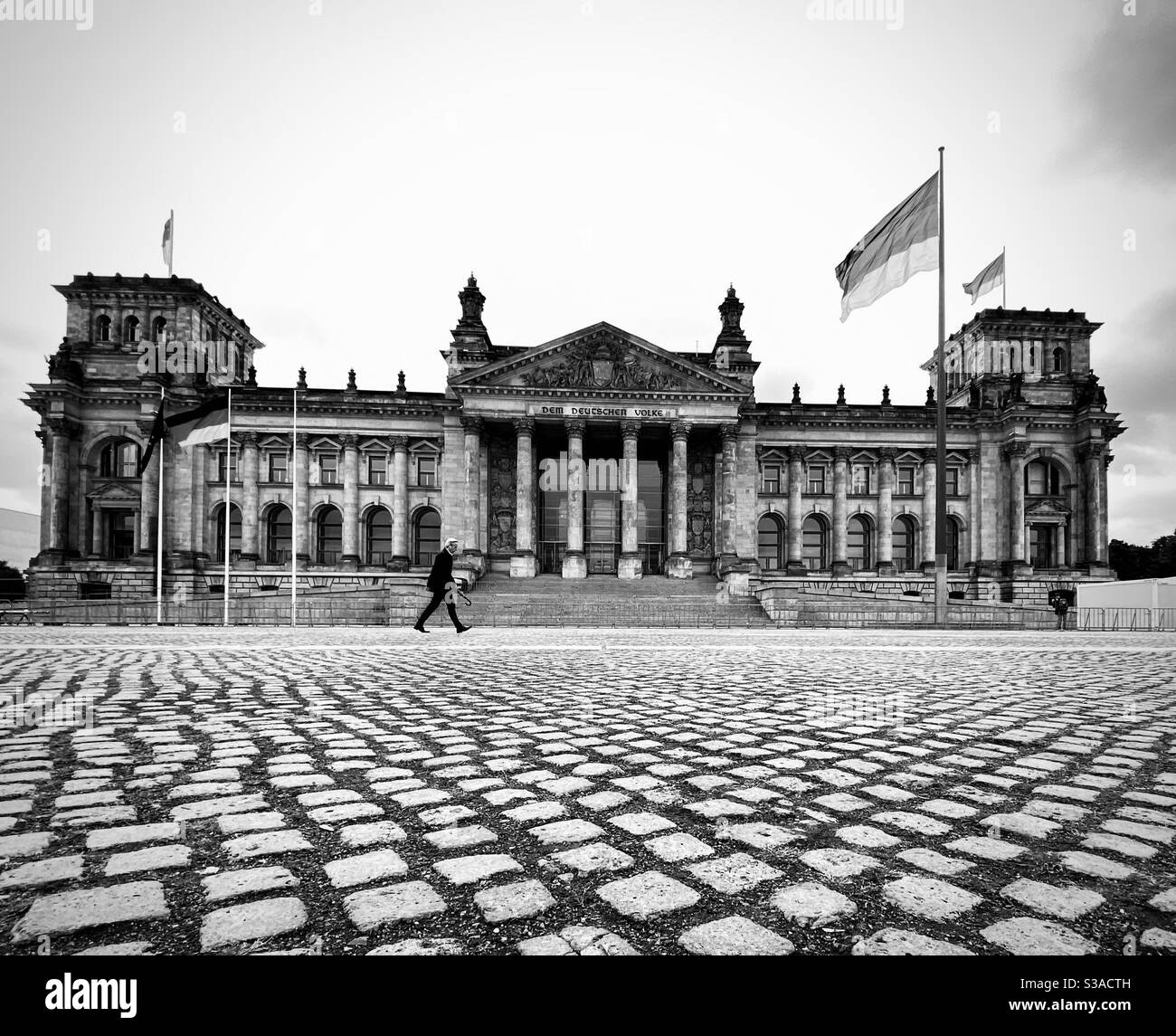 A person walks across the square of the  Reichstag building. Berlin, Germany. - Smartphone Captured Stock Image