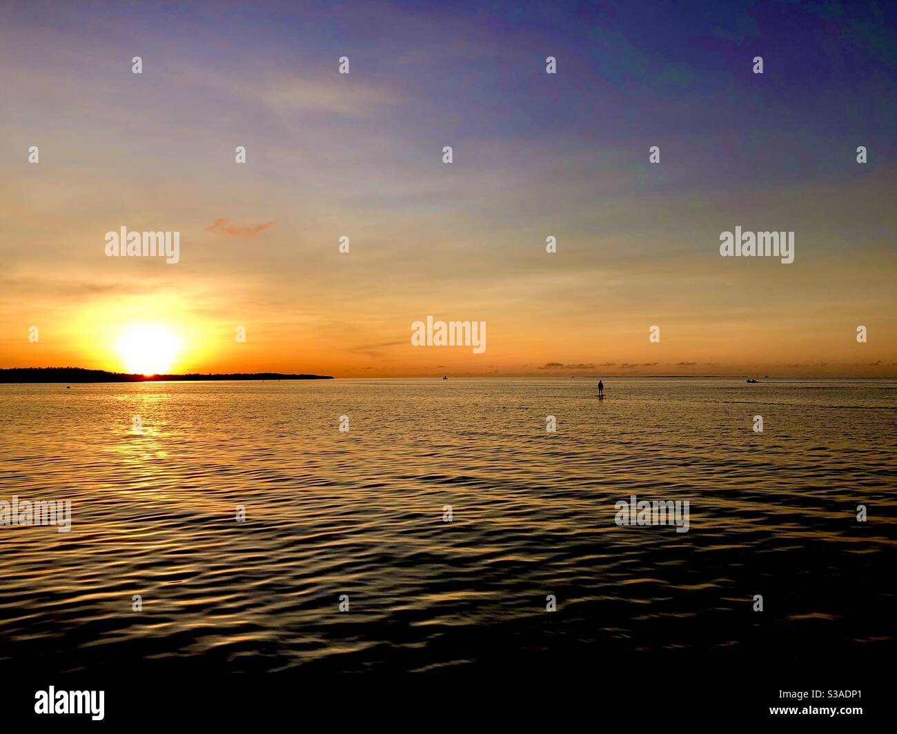 Serene and peaceful scene of a paddle boarder on the Bayside as the sun sets in Key Largo, Florida Stock Photo