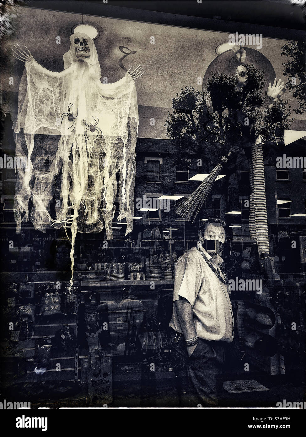 Halloween shop window display with masked salesperson - Smartphone Captured Stock Image