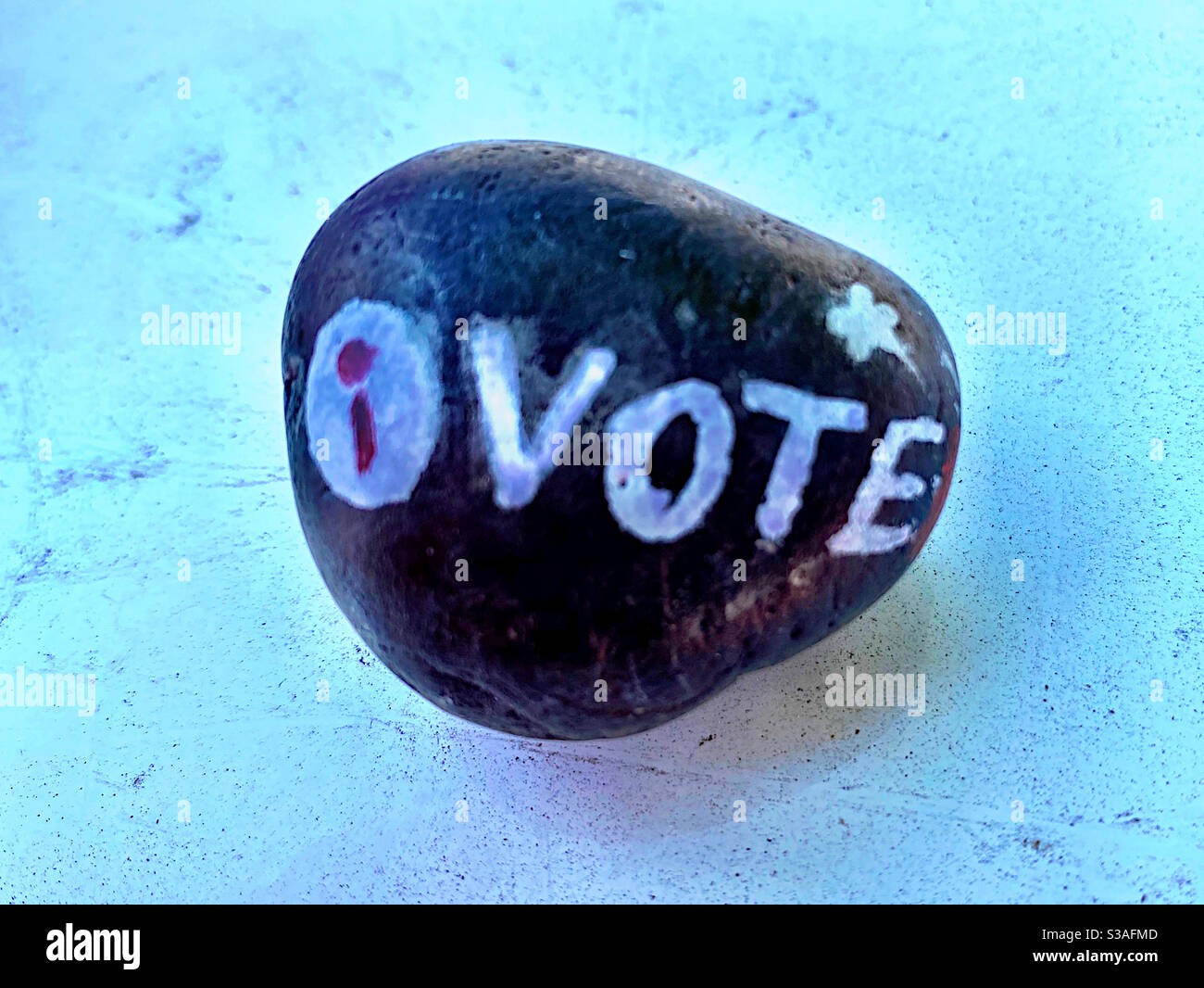 Black rock with VOTE written on it with white letters - Smartphone Captured Stock Image