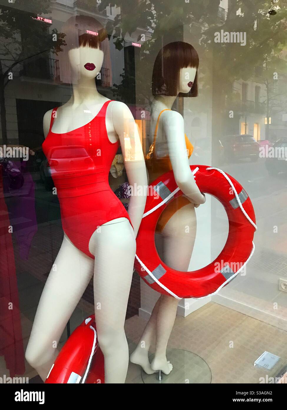Mannequins wearing red swimsuits in a shop window Stock Photo