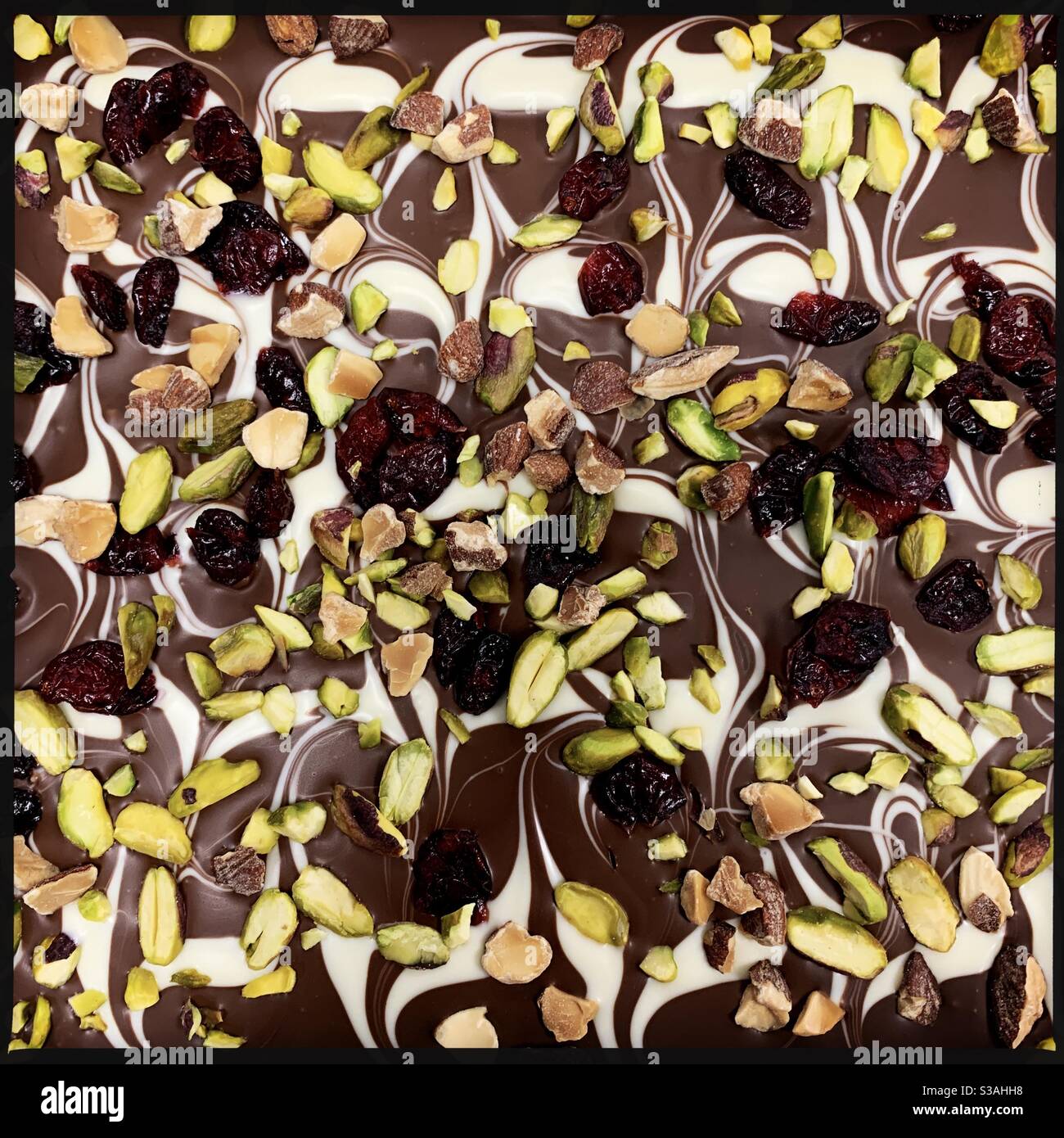 Delicious cake with topping of chocolate, fruit and pistachios - Smartphone Captured Stock Image