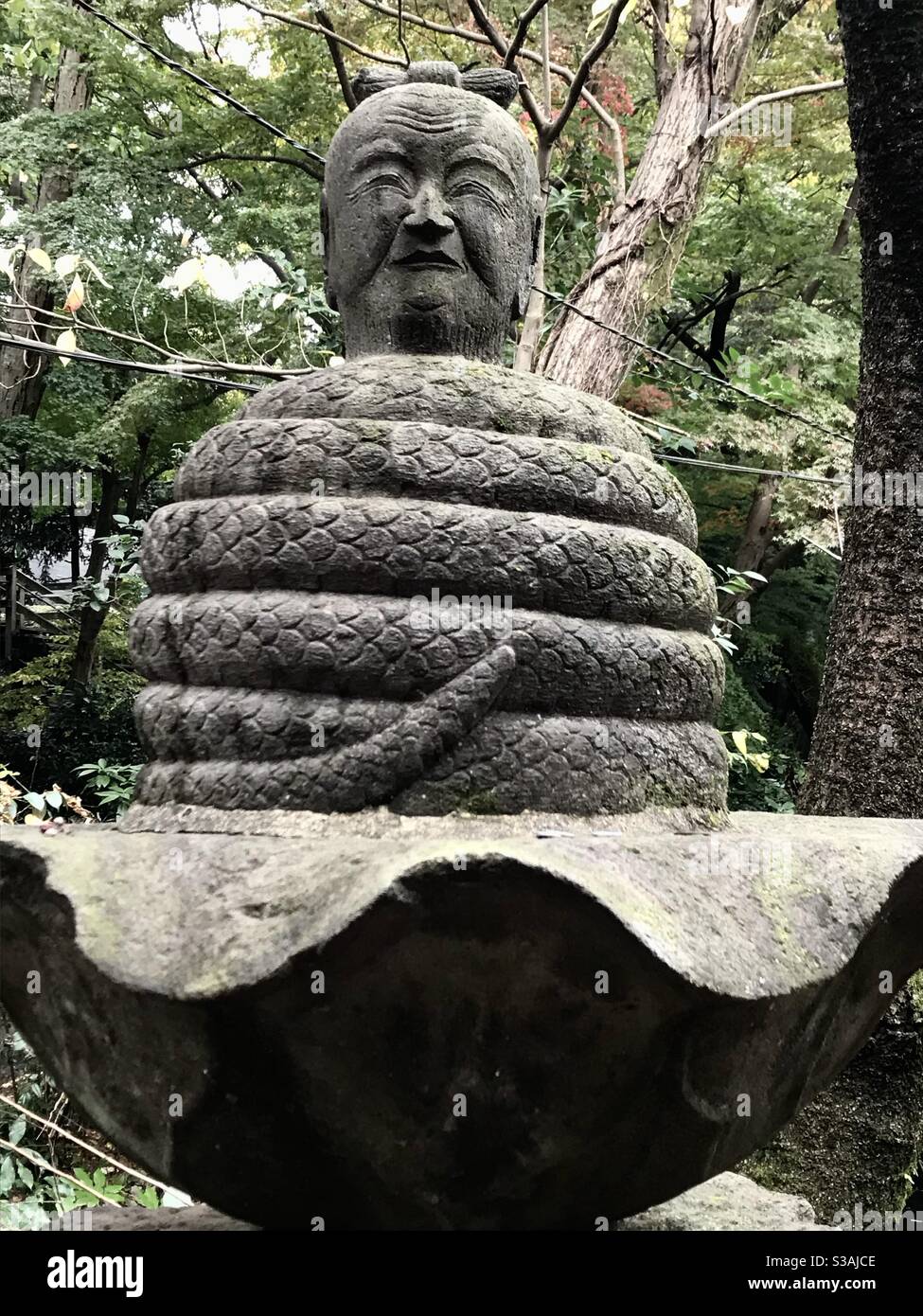 Sculpture of serpent coil topped with a head at Inokashira Benzaiten Buddhist temple in Inokashira Park, Kichijoji, Tokyo, Japan. - Smartphone Captured Stock Image