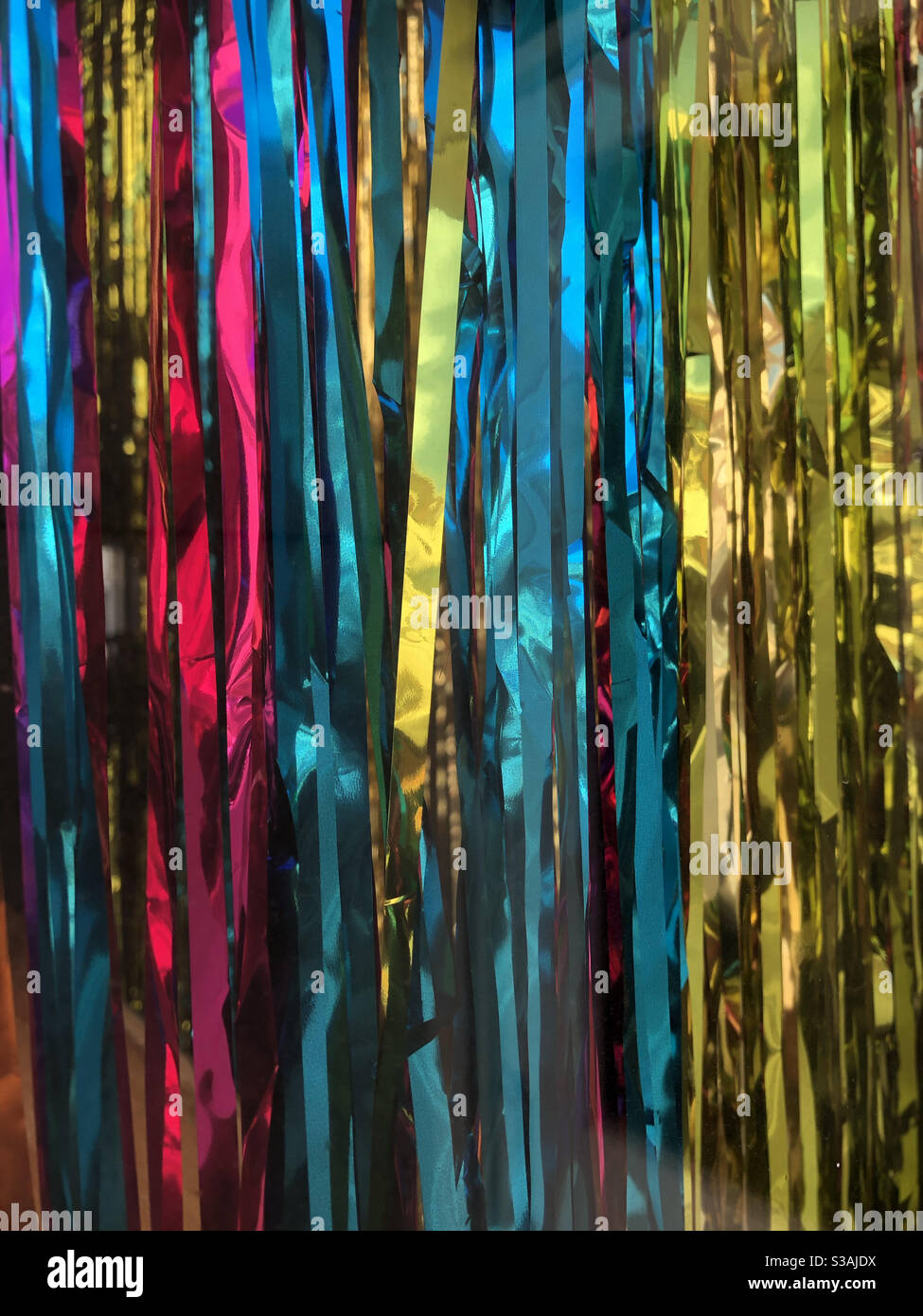 Fun colorful metallic strips of Mylar streamers over door at party or celebration - Smartphone Captured Stock Image