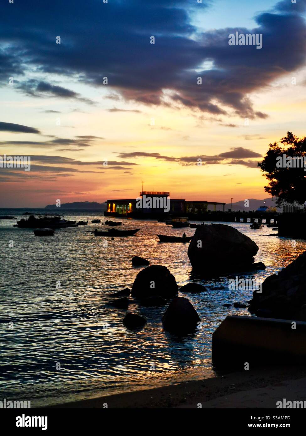 a beautiful sunset over the Yung shue wan pier on Lamma island in Hong kong. - Smartphone Captured Stock Image
