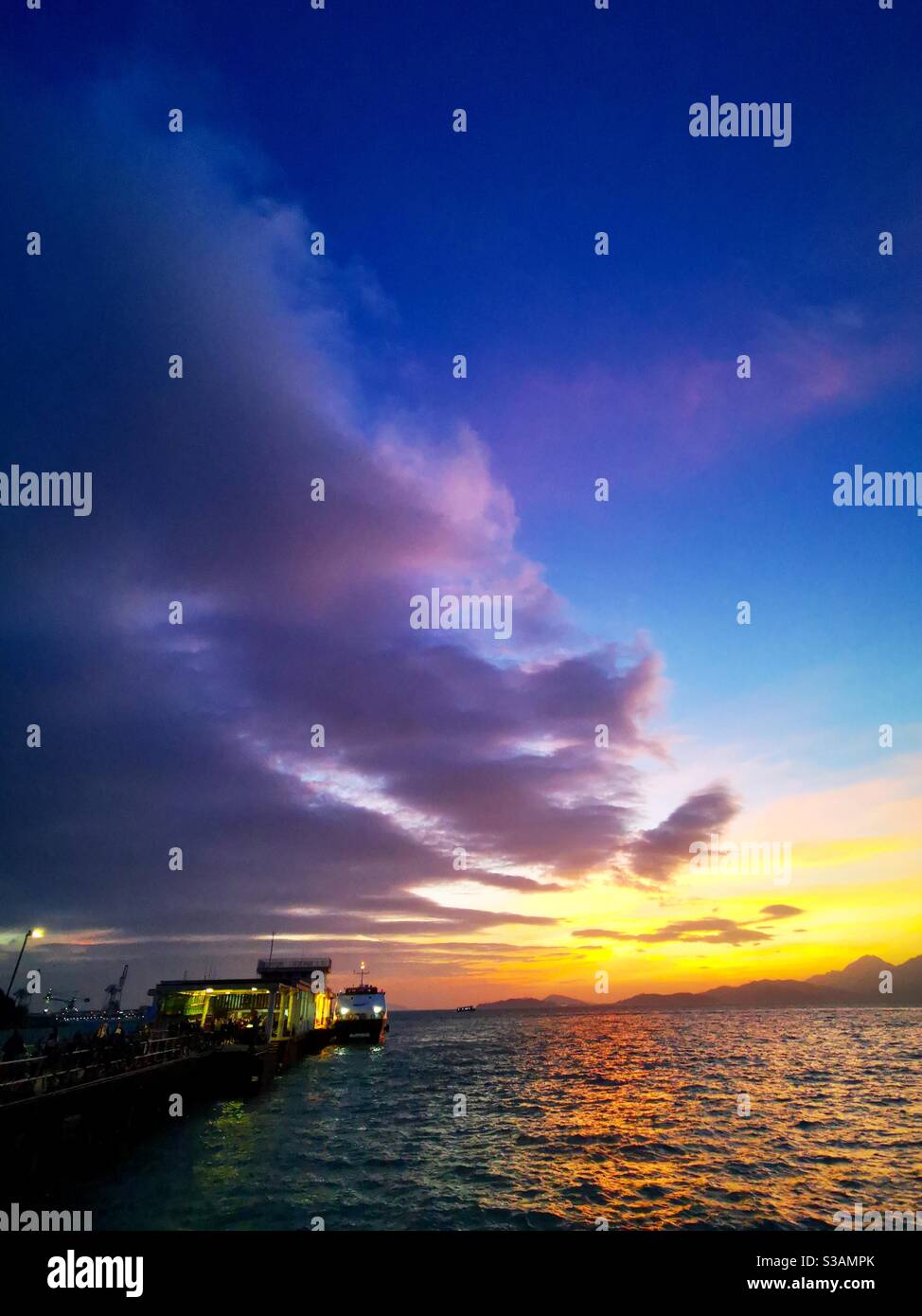 A beautiful sunset over the Yung shue wan pier on Lamma island in Hong kong. - Smartphone Captured Stock Image