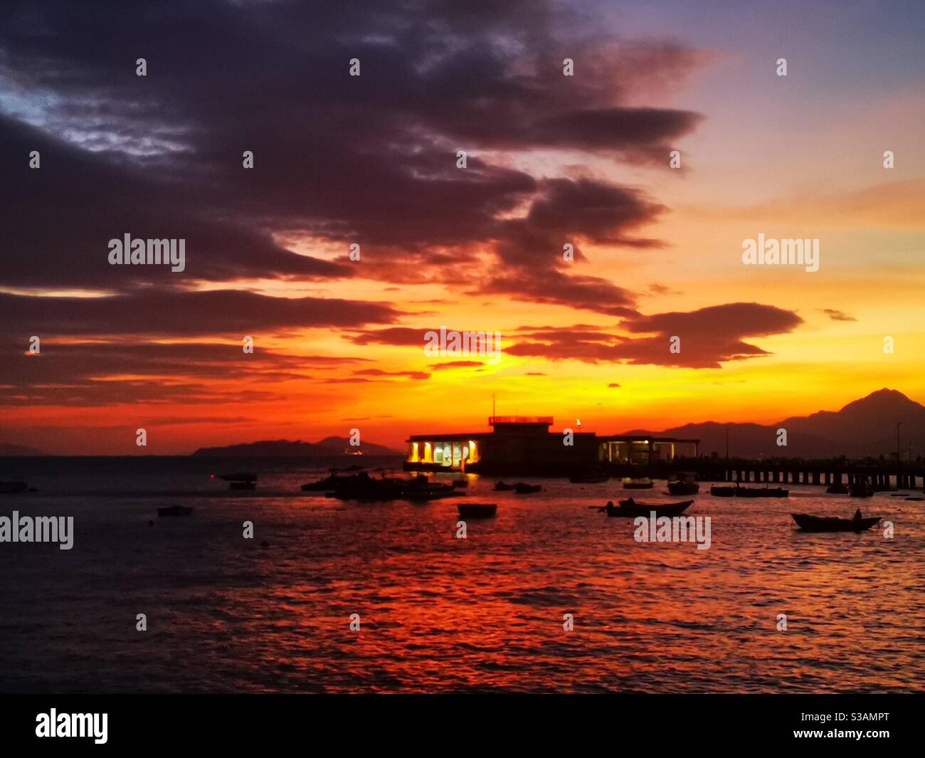 A beautiful sunset over the Yung shue wan pier on Lamma island in Hong kong. - Smartphone Captured Stock Image