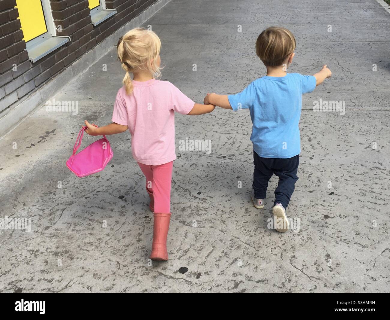 toddlers running holding hands Stock Photo