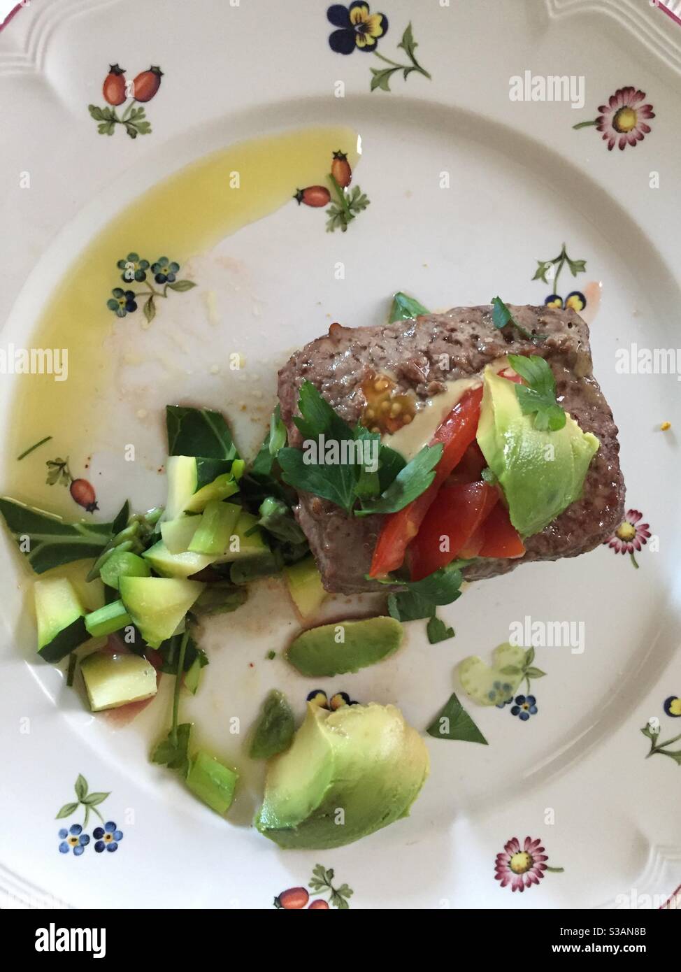 Organic Grass fed burger with tomato avocado, collard greens  and zucchini Stock Photo