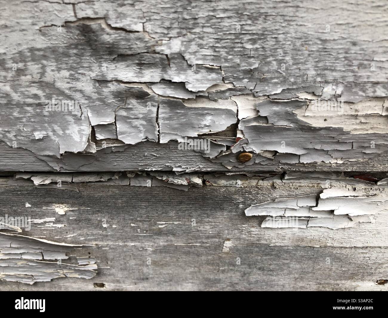 Extreme close up on cracked, peeling white paint on the outside wall of an old house Stock Photo