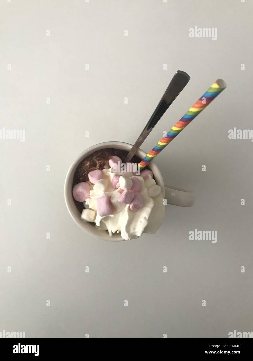 A mug of hot chocolate topped with whipped cream and mini marshmallows - Smartphone Captured Stock Image