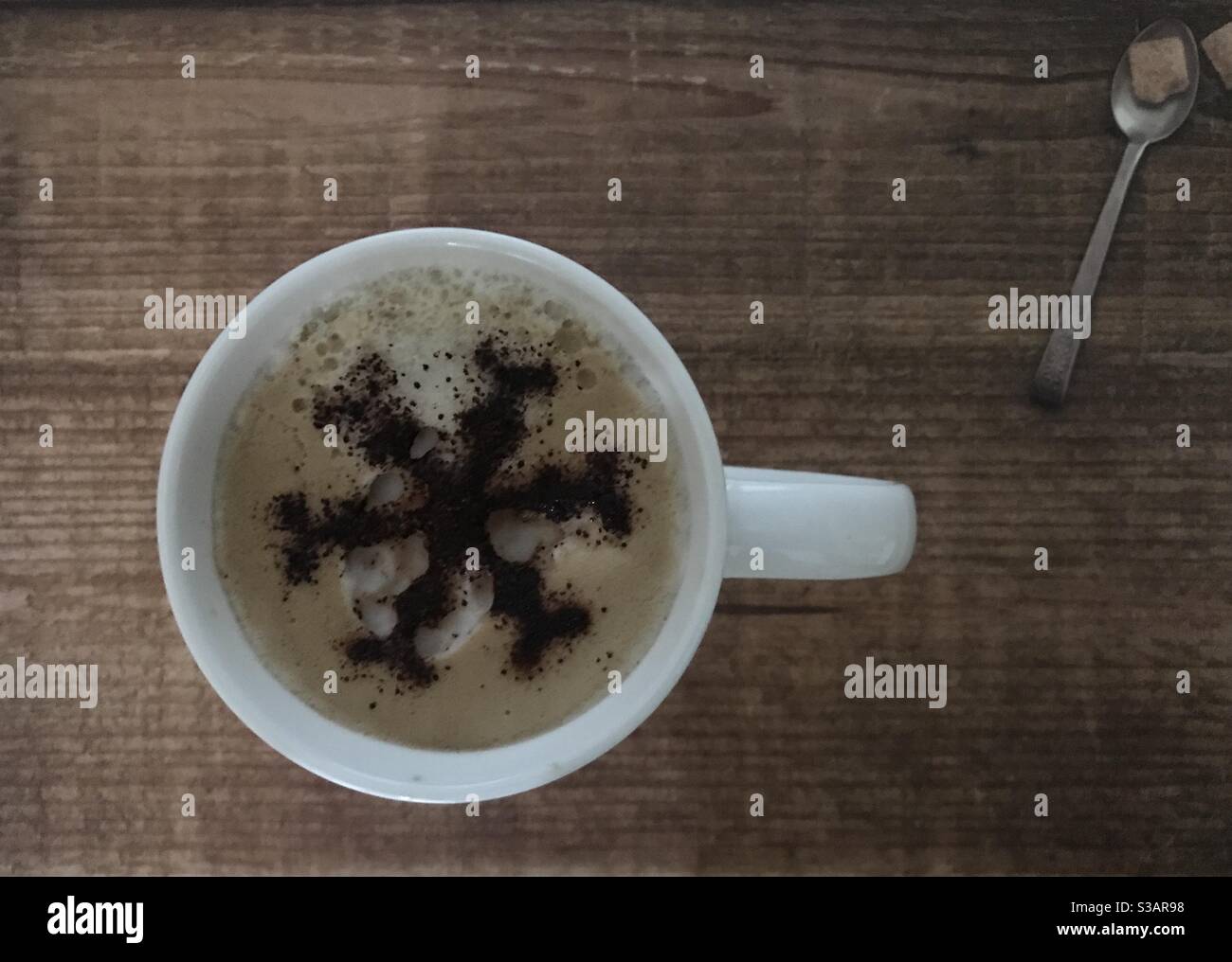 Snowflake design on a cup of cappuccino coffee - Smartphone Captured Stock Image