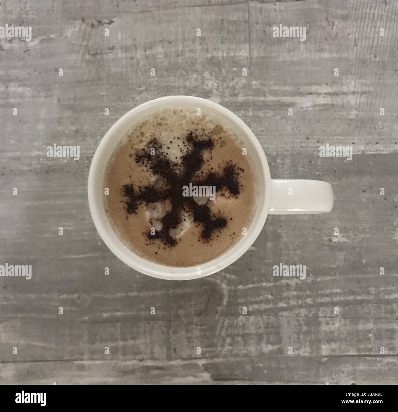 Snowflake design on a cup of cappuccino coffee - Smartphone Captured Stock Image