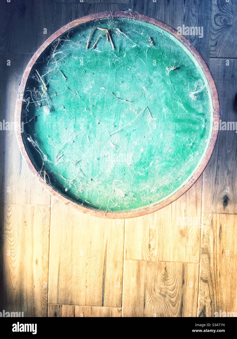 dusty round ton on wooden floor in morning light copy space - Smartphone Captured Stock Image