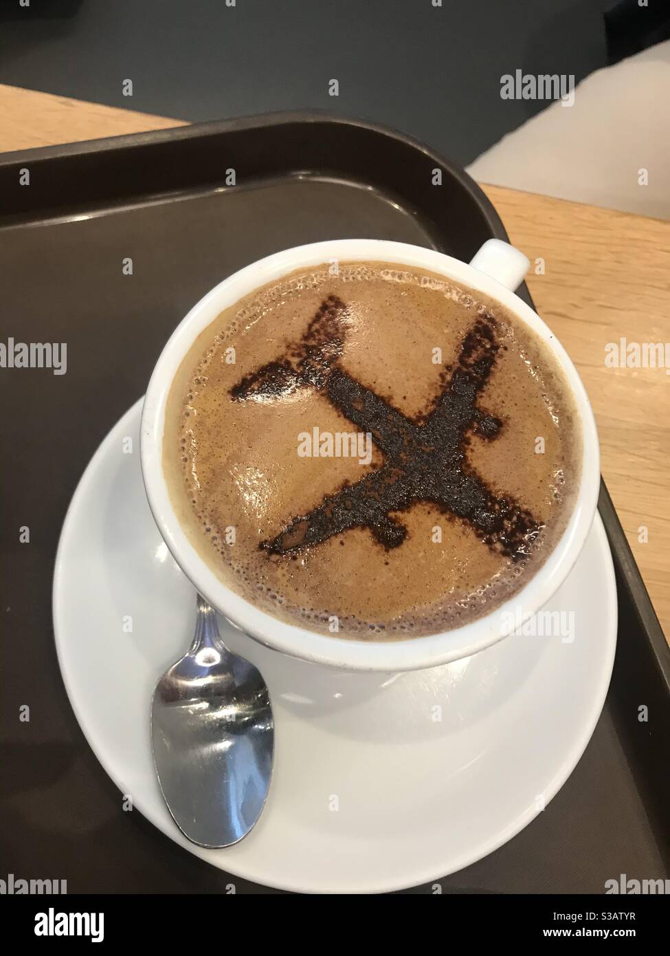 Airplane design on a cup of cappuccino coffee - Smartphone Captured Stock Image