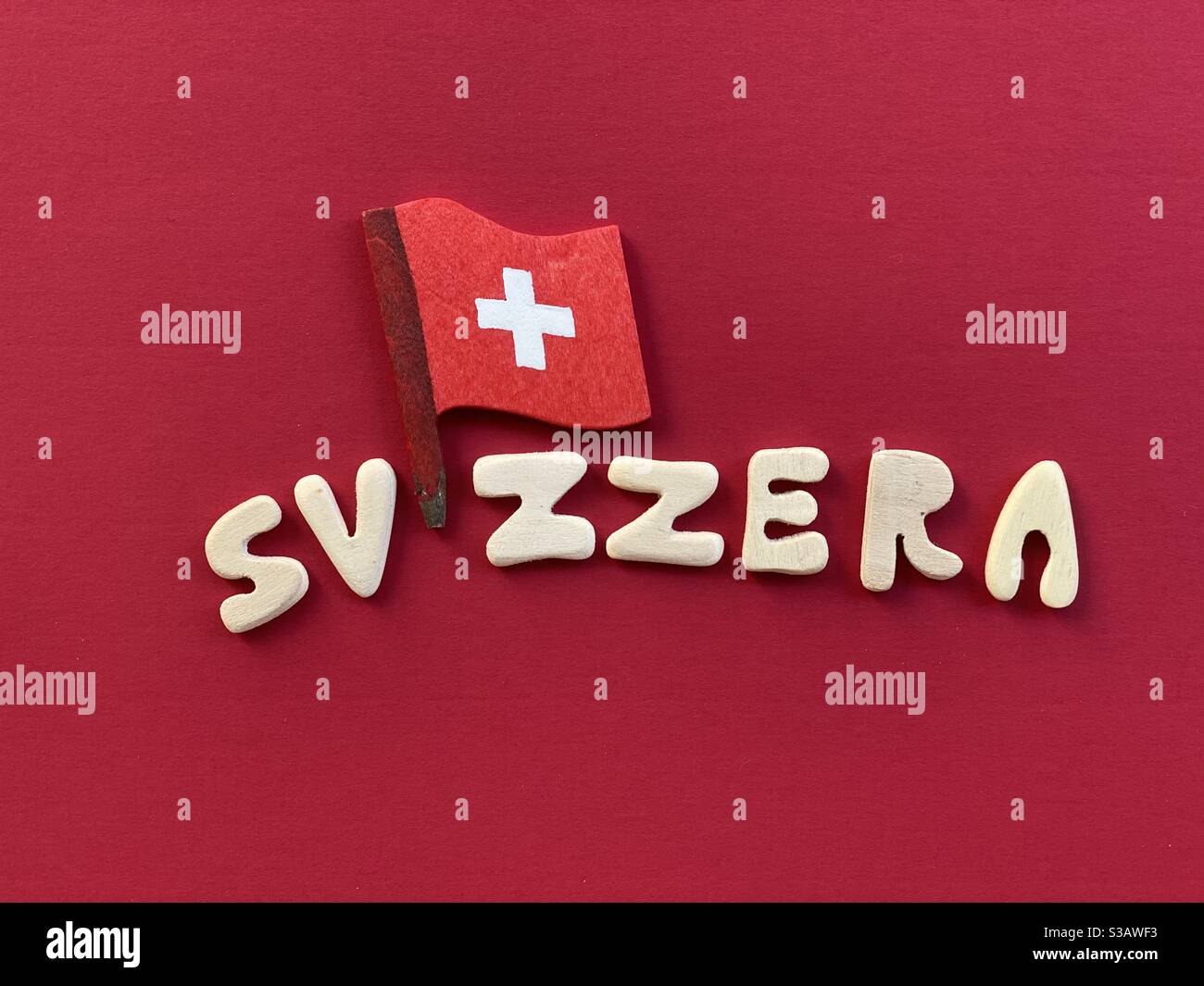 Svizzera, central Europe country in italian language composed with wooden letters and national wooden flag over red  wooden board - Smartphone Captured Stock Image