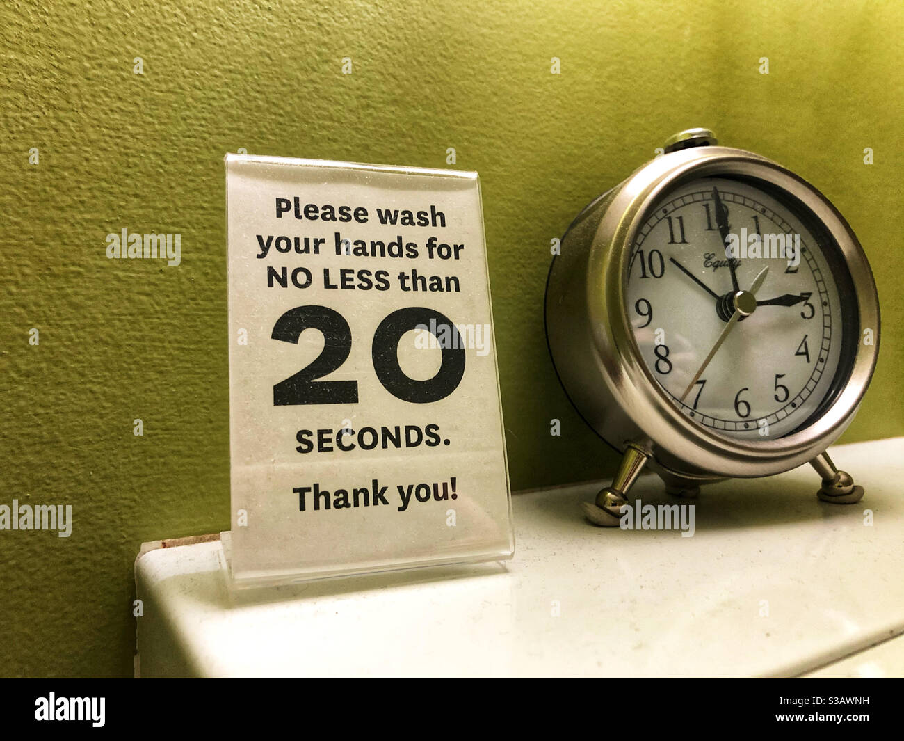 Instructions for washing hands during Covid pandemic, and clock to time it in public washroom - Smartphone Captured Stock Image