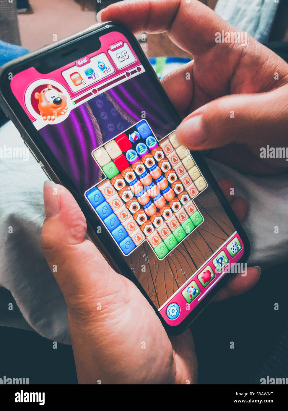 A lady plays a game on her smartphone. Stock Photo
