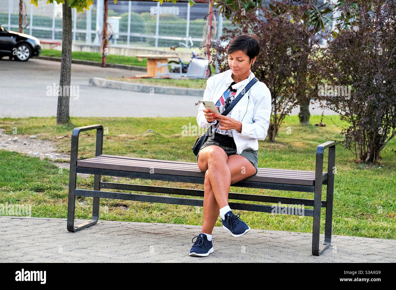 Woman sitting on a bench using a mobile phone - Smartphone Captured Stock Image