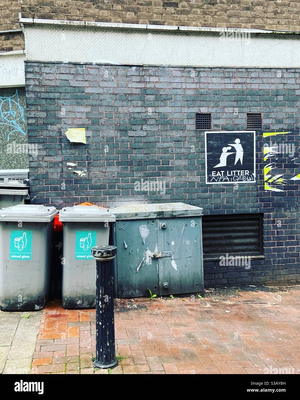 Foka Wolf Eat Litter poster in Birmingham next to some bins - Smartphone Captured Stock Image