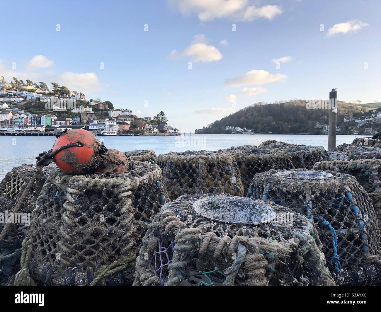 Fishermen’s Crab Pots on the Embankment in Dartmouth looking  across the River Dart to Kingswear with Dartmouth Castle in background - Smartphone Captured Stock Image