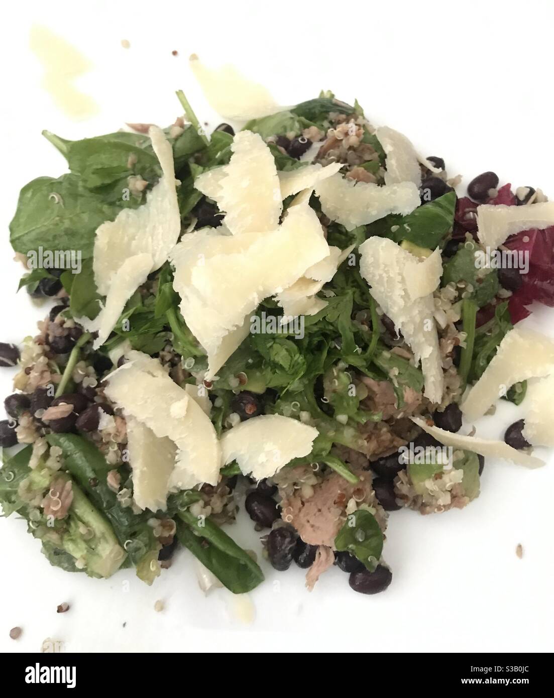 Tuna, bean, avocado and quinoa salad topped with shavings of Parmesan cheese and served in a white bowl - Smartphone Captured Stock Image