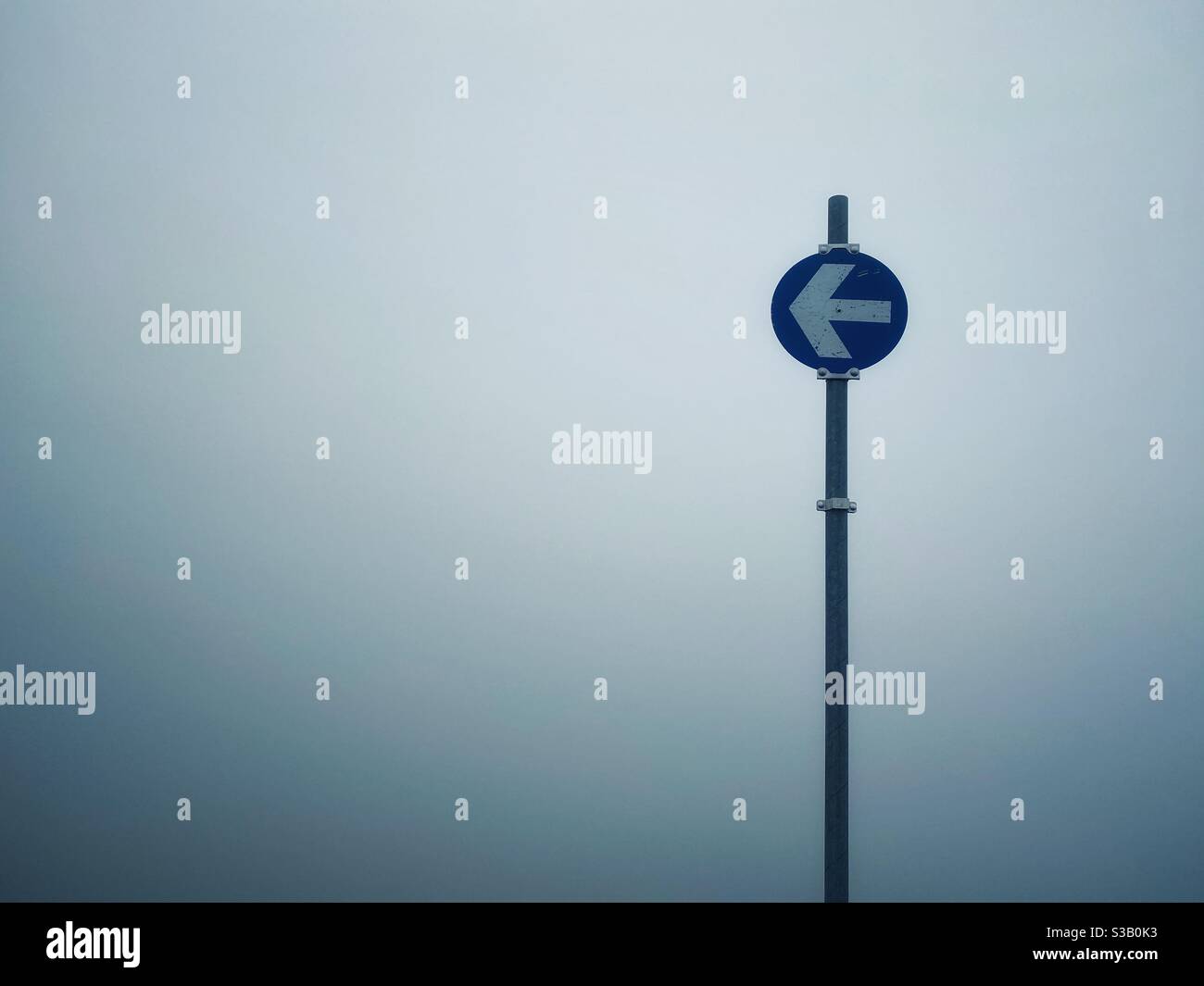 A sign with an arrow in the Fog - Smartphone Captured Stock Image