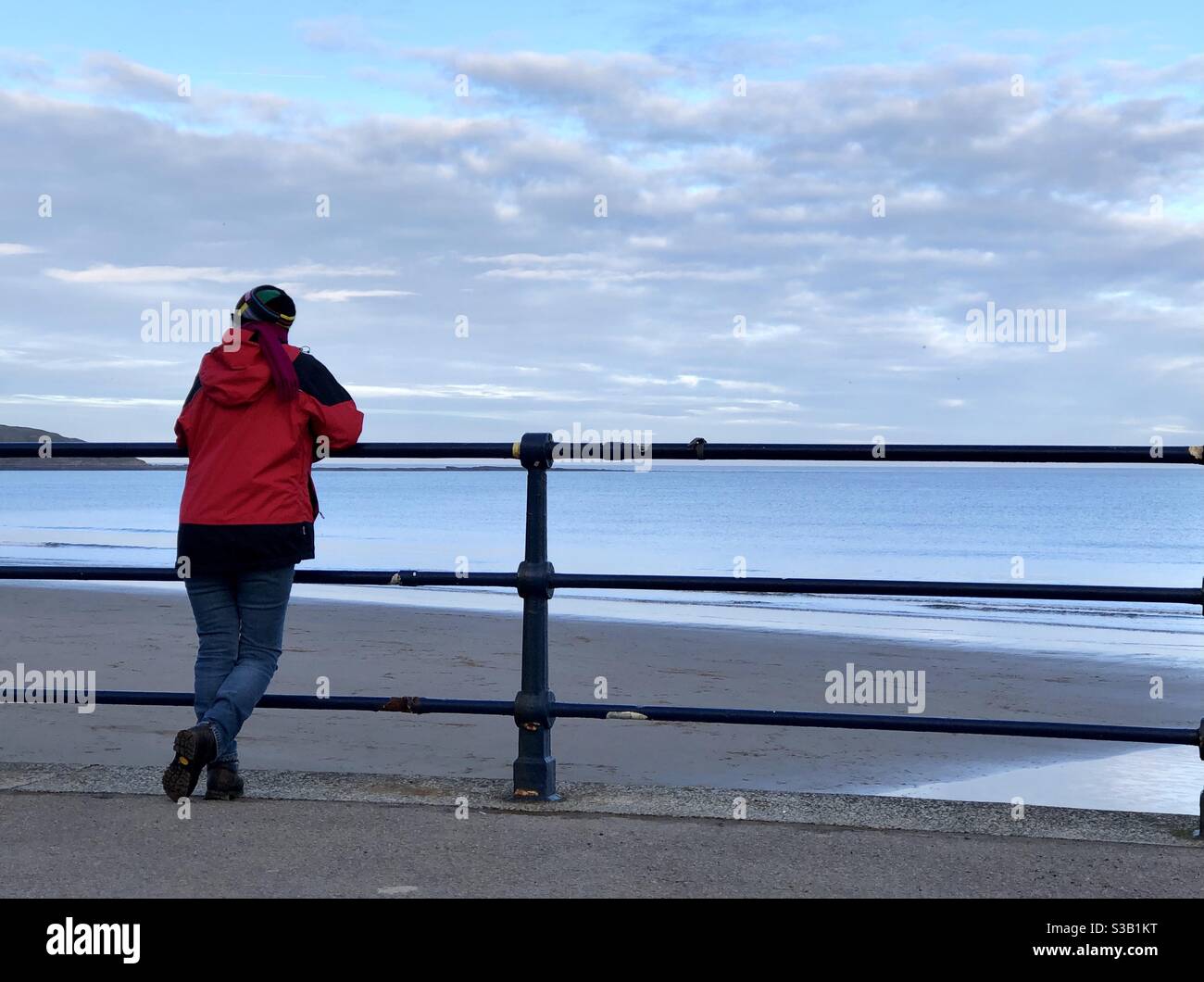 Woman leaning on railings watching the sea - Smartphone Captured Stock Image