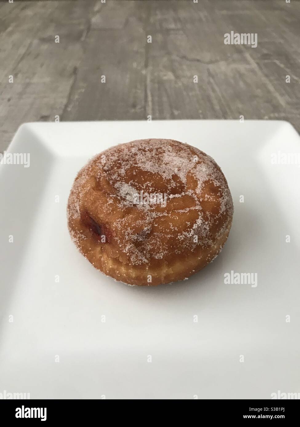 Jam doughnut on a white plate Stock Photo