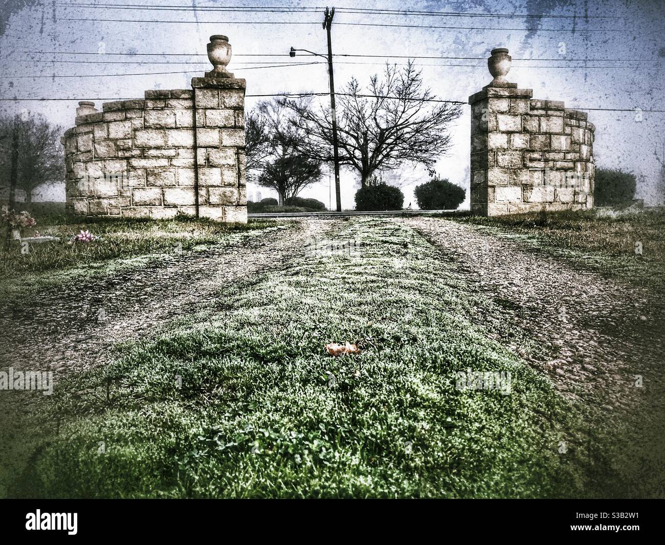Stone structure marks entrance to cemetery path in bleak, winter photo - Smartphone Captured Stock Image