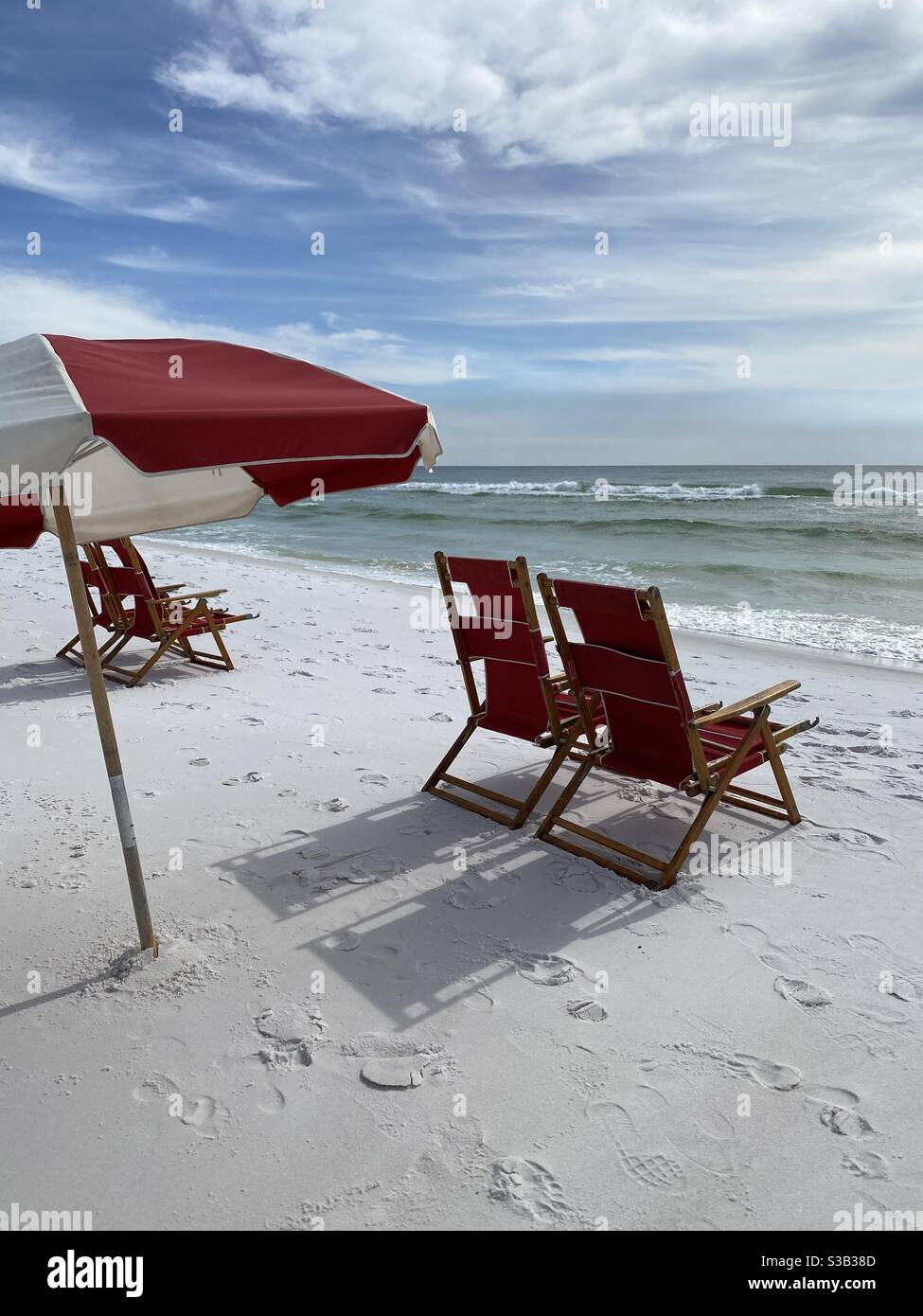 Colorful red lounge chairs and outdoor umbrella on white sand Florida