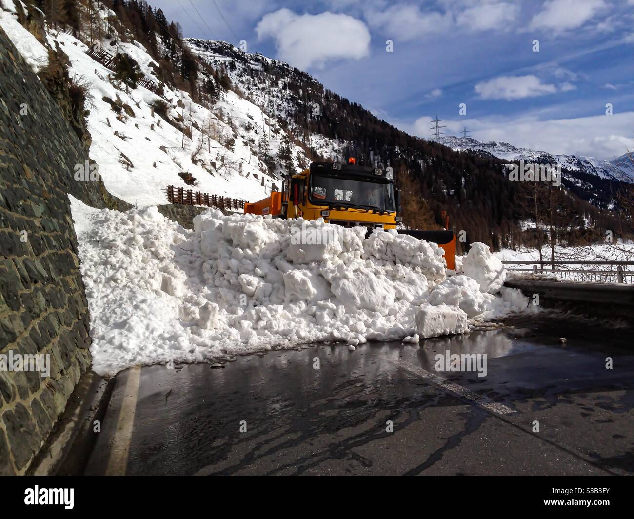 avalanche snow on road being removed by snowplow truck - Smartphone Captured Stock Image