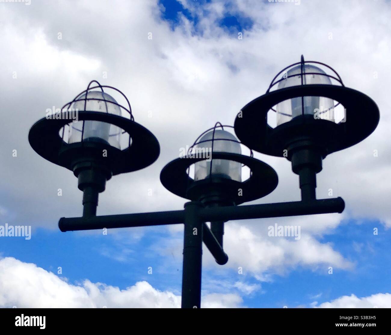 Light fixtures against blue sky with clouds Stock Photo