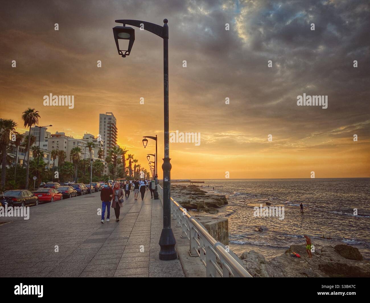 Charming sunset with people enjoying a walk at Beirut Lebanon promenade Stock Photo