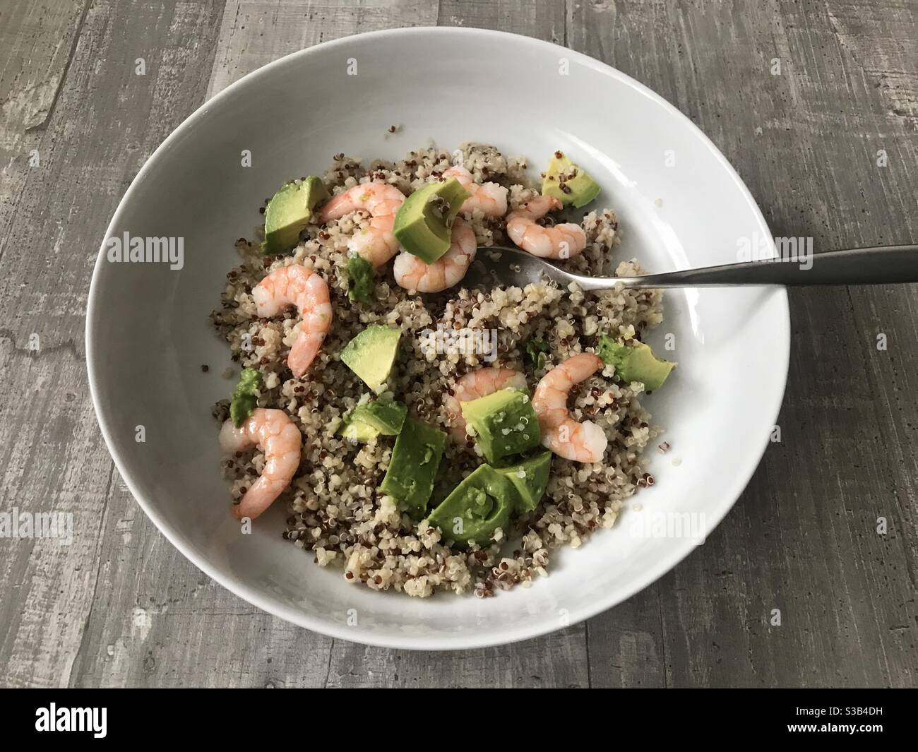 Fresh prawn, avocado and quinoa salad against a wooden background - Smartphone Captured Stock Image