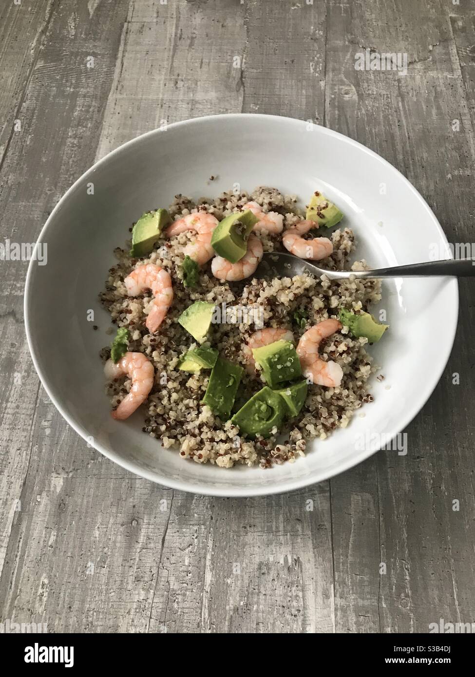 Fresh prawn, avocado and quinoa salad against a wooden background - Smartphone Captured Stock Image