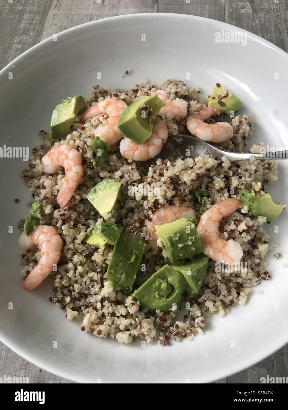 Fresh prawn, avocado and quinoa salad against a wooden background - Smartphone Captured Stock Image