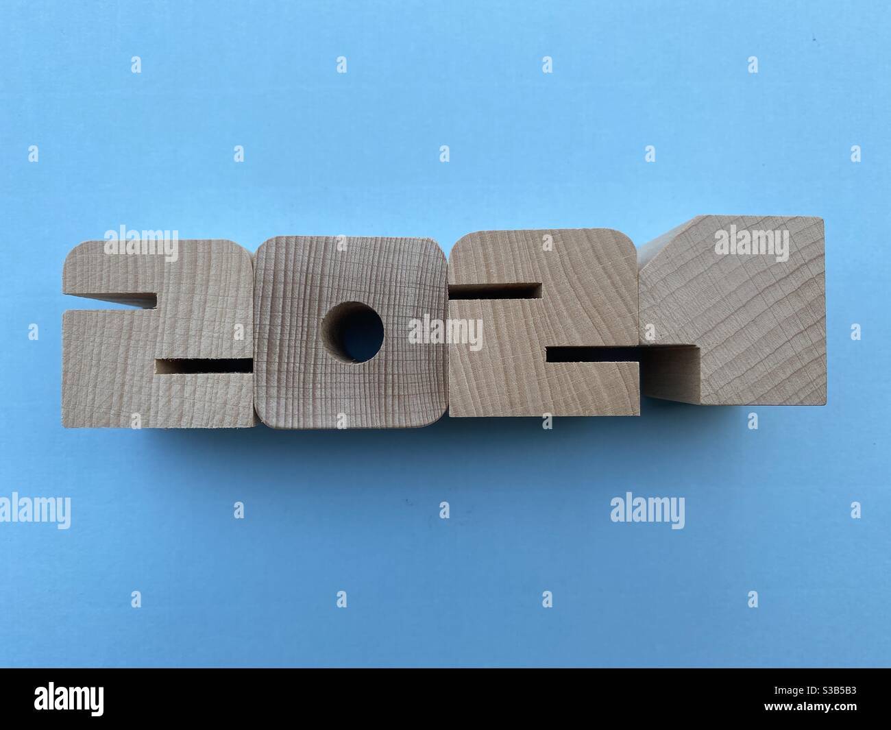 Year 2021 composed with wooden numbers over blue background Stock Photo